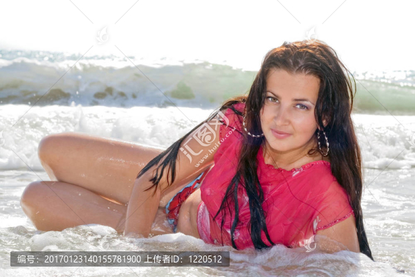 美麗的年輕女子躺在海邊