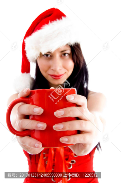 迷人的年輕女性在圣誕帽持有咖啡杯