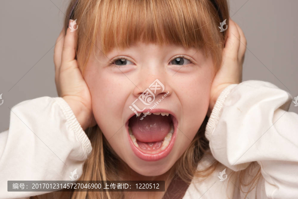 年輕的紅頭發(fā)女孩覆蓋了她的耳朵