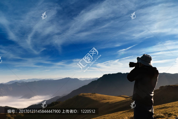 一個(gè)攝影師站在室外拍攝有云。