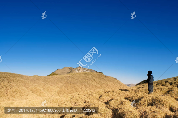 一個人站在山上金色的陽光。