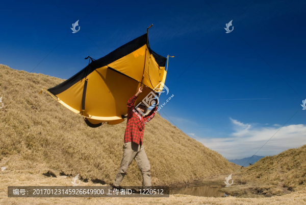 一個(gè)男人在高山上搭起了帳篷。