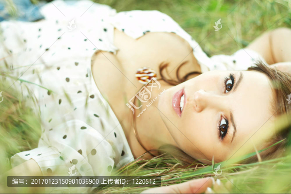 美麗的女孩躺在草地上