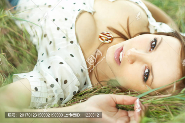 美麗的女孩躺在草地上