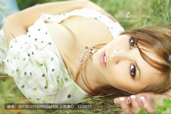 美麗的女孩躺在草地上