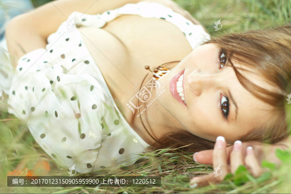 美麗的女孩躺在草地上
