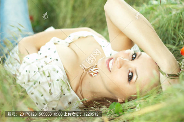 美麗的女孩躺在草地上