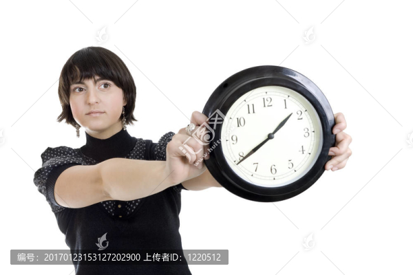 cacasian女人抱著墻上的時(shí)鐘
