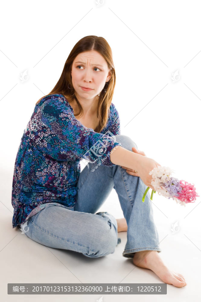 寂寞的女人坐在手拿鮮花的身姿