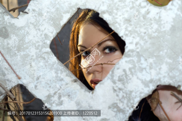 年輕的女人透過籬笆看