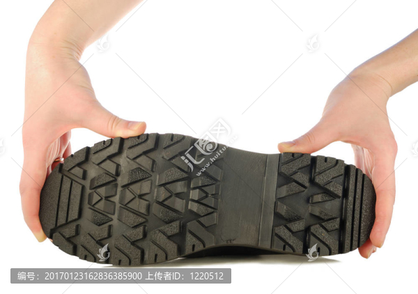 在一只手上的粗糙的靴子的鞋底
