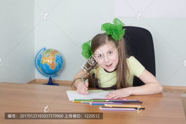 女孩坐在一張有鉛筆的桌子上