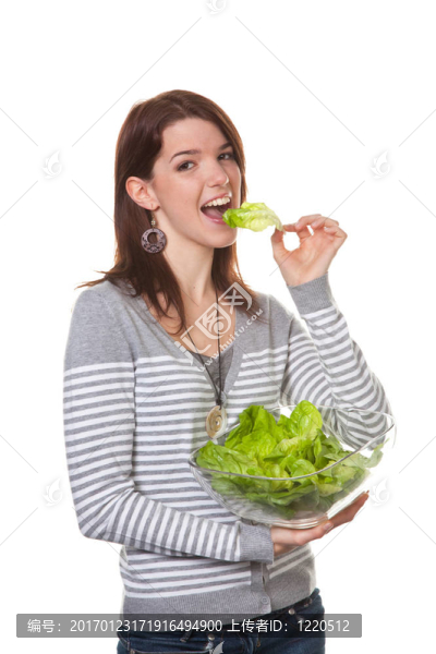 一個年輕的女人嘗試了一個綠色沙拉