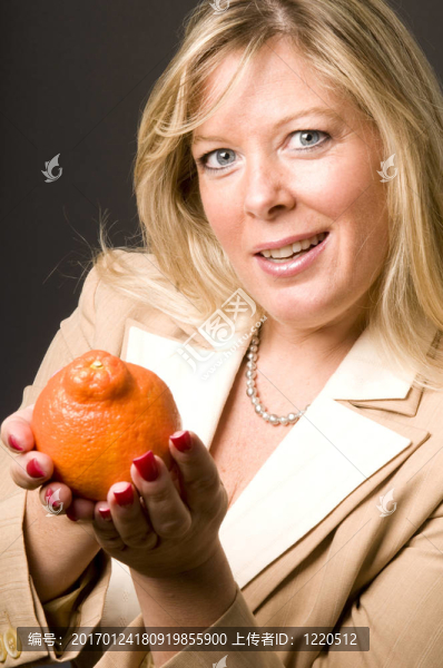 迷人的金發(fā)女人Mineola橙色Tangerine夜店新鮮水果的健康生活