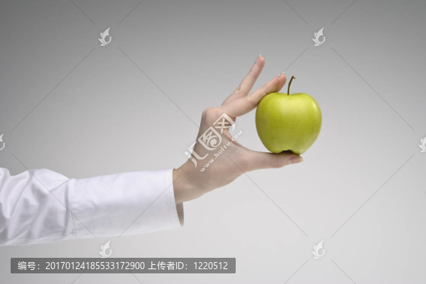 女人的手拿著一個蘋果