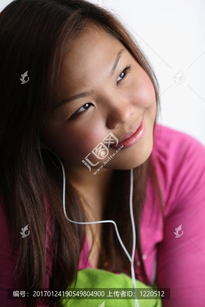 年輕女子聽音樂；床上放松。