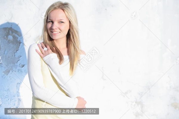 美麗的年輕女子站在一個老墻在下午晚太陽（高關鍵）