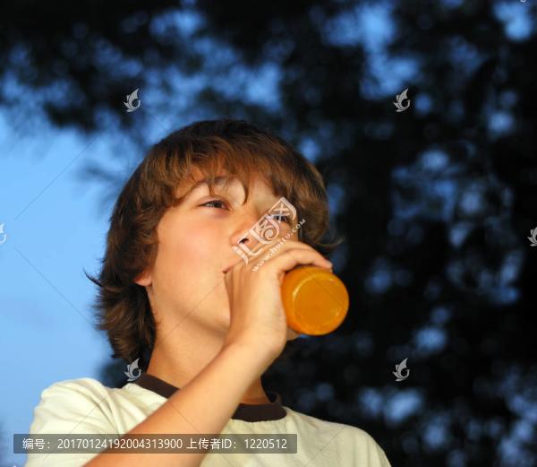 十幾歲的男孩喝橙汁飲料