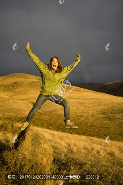 從巖石上跳的十幾歲的女孩