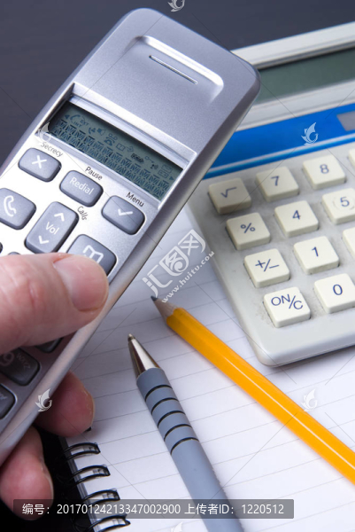 電話和計算器在螺旋筆記本上