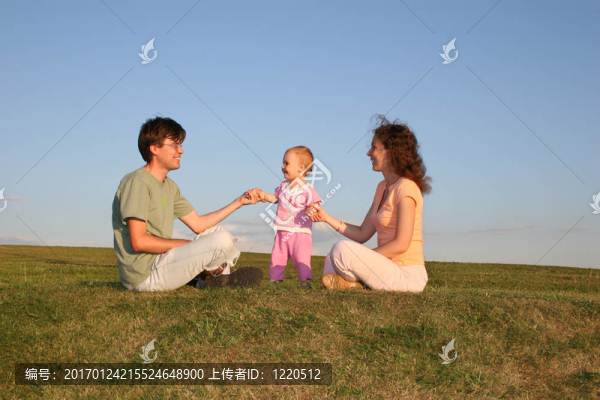 家庭與嬰兒坐在草地上