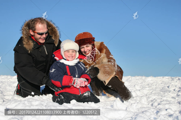 冬天的家人坐在雪地上