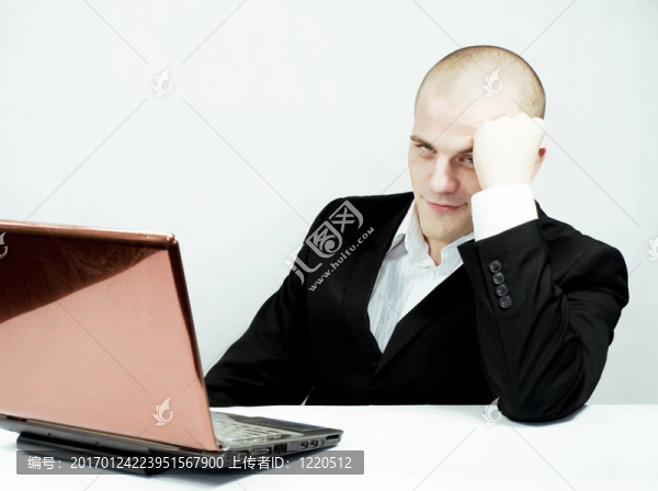 年輕的；疲倦的人在辦公室里帶著筆記本電腦