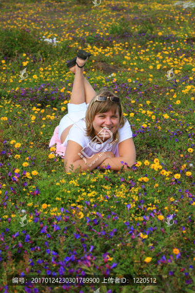 年輕的女孩在一朵鮮花的草地上
