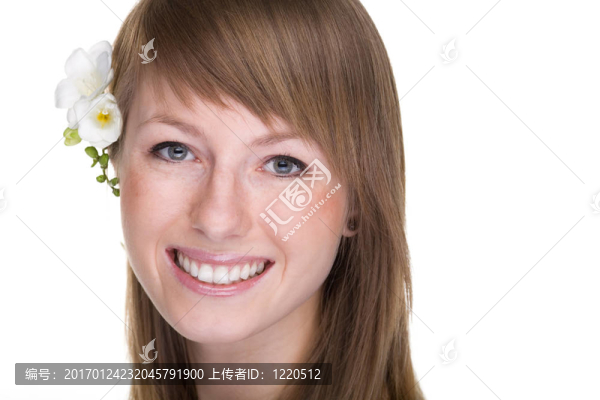 美麗的女人微笑著看著相機花。