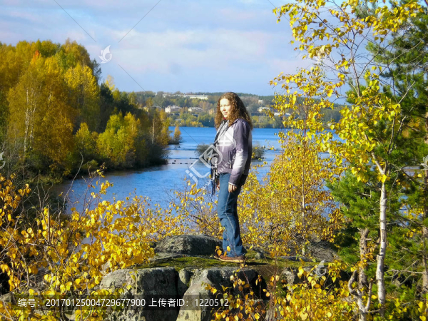 女人站在巖石的邊緣，透過(guò)遠(yuǎn)處看