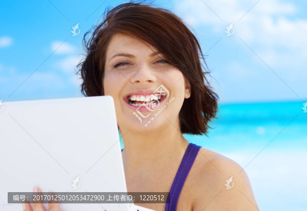 海灘上帶著筆記本電腦的女人