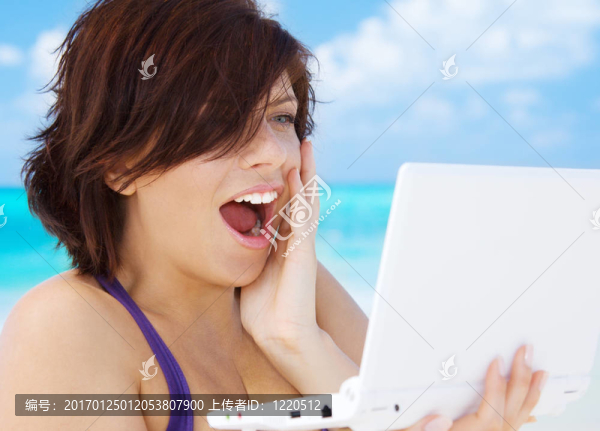 海灘上帶著筆記本電腦的女人