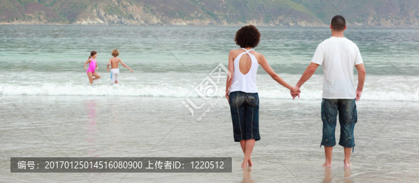 年輕的夫婦在海灘上牽著手