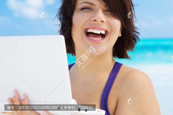 海灘上帶著筆記本電腦的女人