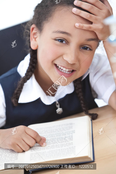 漂亮的年輕學校女孩讀一本書