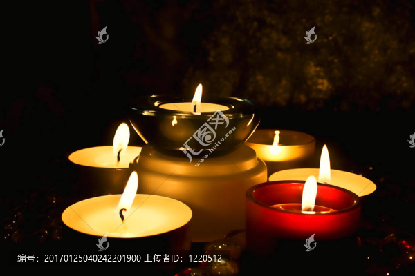 一群反對黑暗背景的蠟燭