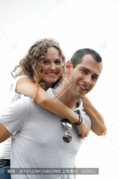 快樂的年輕人給予微笑的美麗的女人背著