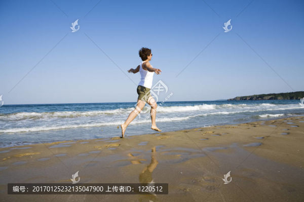 年輕的女孩在海灘上跑步