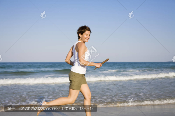 在海灘上跑步的年輕女孩
