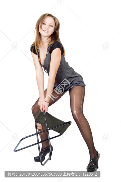 年輕女子在撕破的長筒襪里帶著一把椅子