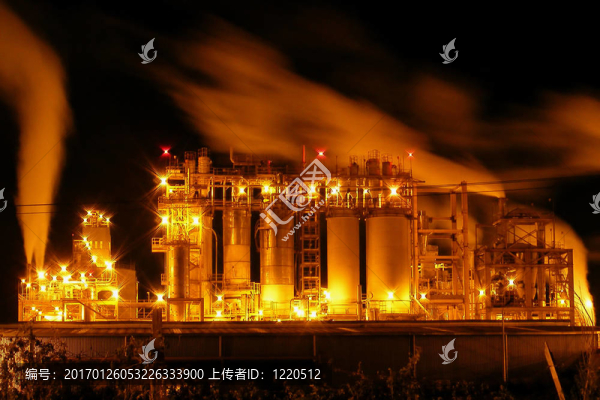 具有許多照明和蒸汽煙囪和鋼管的工業(yè)廠房的夜景。