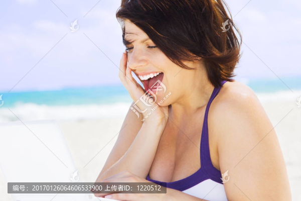 海灘上帶著筆記本電腦的女人