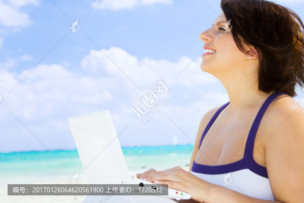 海灘上帶著筆記本電腦的女人