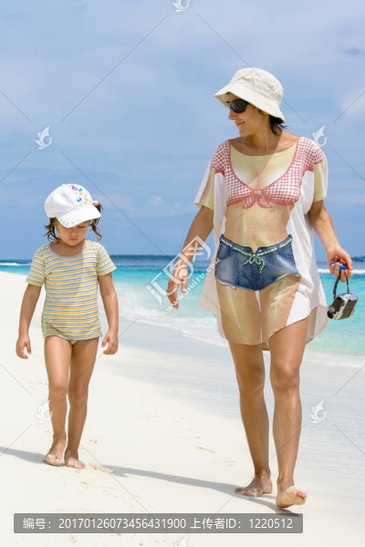 女兒和母親在海灘上散步