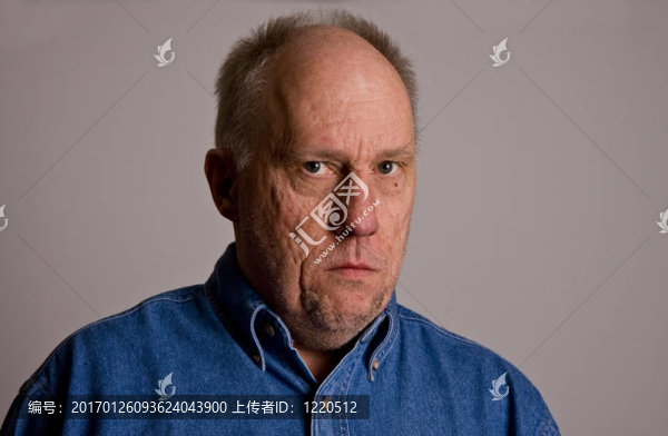 穿著藍色牛仔襯衫的老禿家伙不信任