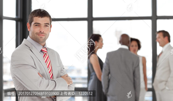 在隊(duì)伍前面折疊雙臂的高級(jí)商務(wù)人員