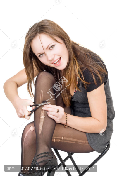 女孩用剪刀剪絲襪。分離