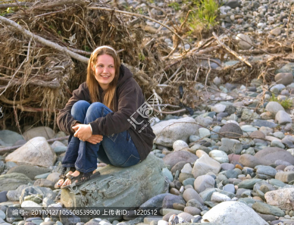 自然的黑發(fā)女子坐在巖石上