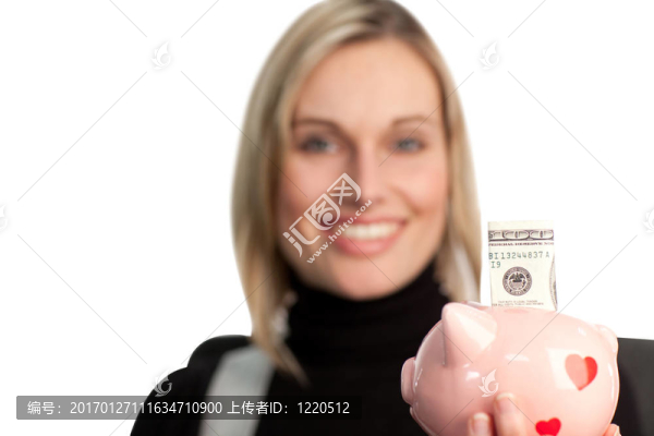迷人的商業(yè)婦女抱著存錢罐
