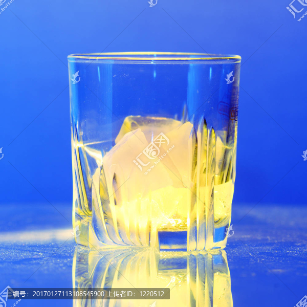 布滿灰塵的桌子上燃燒的冰的威士忌玻璃杯